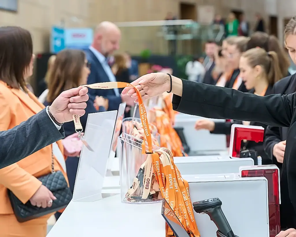 Badges werden auf einem Event verteilt, nachdem sie von dem Check-In-System der plazz AG registriert und bedruckt wurden